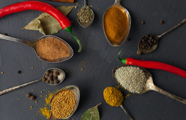 circle of spoons with different colored spices