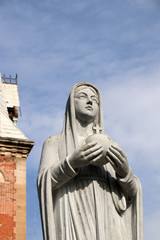 Virgin Mary Statue in front of Notre-Dame Cathedral Basilica of Saigon in Ho Chi Minh City (Vietnam) against a blue sky