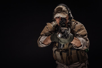 Portrait soldier or private military contractor holding sniper rifle. war, army, weapon, technology and people concept. Image on a black background.