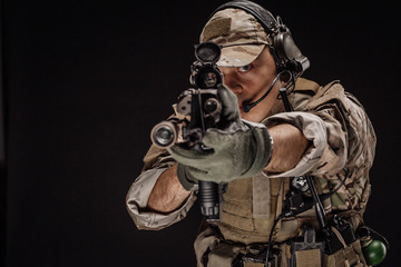 Portrait soldier or private military contractor holding sniper rifle. war, army, weapon, technology and people concept. Image on a black background.