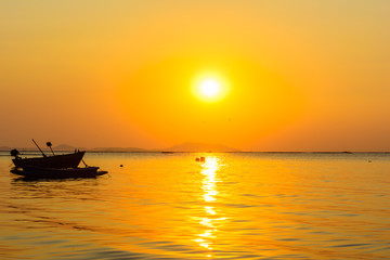 Naklejka na ściany i meble Boat and the beach with sunset background