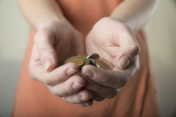 hand drops money into a glass jar for a savings