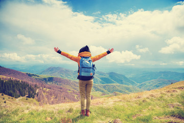 Girl enjoying on a mountain top with arms wide open.
