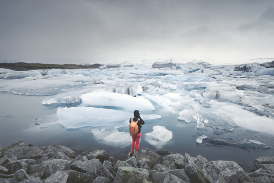 Iceland, view of Joekulsarlon, glacial river lagoon with man standing in the foreground