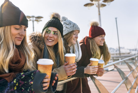 Four friends with coffee to go in winter