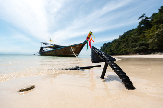 Thai longtail boat anchoring on a white sand beach