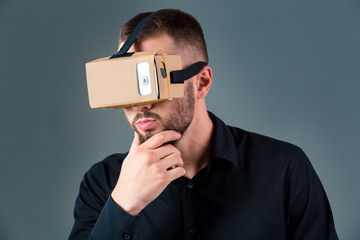 Man using a new virtual reality headset on grey background