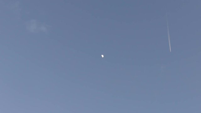 Half moon. Passing aircraft.