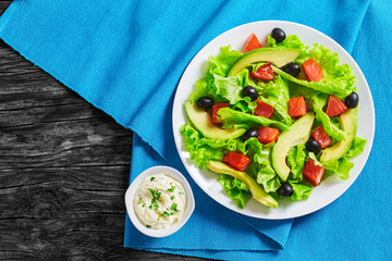 red fish, fresh lettuce, avocado, black olives salad