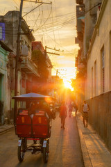 Fototapeta premium Street scene in Old Havana illuminated by the sun at sunset