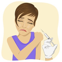 Sad young woman getting vaccination procedure