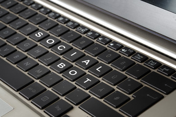 Computer laptop keyboard with the words SOCIAL BOT in white letters on black keys