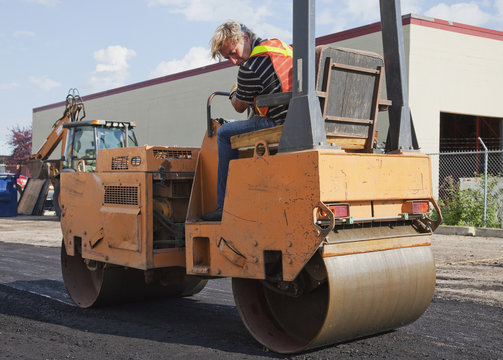Operator driving steam roller repairing pot holes; Edmonton, Alberta, Canada
