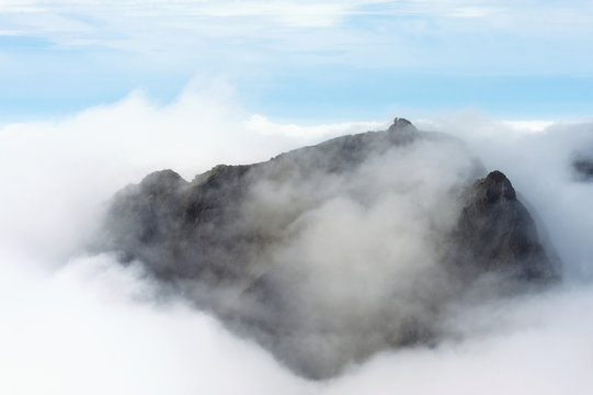 The top of a mountain emerging above clouds in the Black Cuillin; Isle of Skye, Scotland