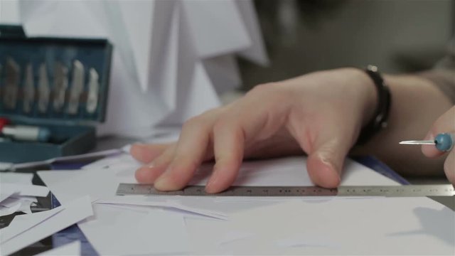 Man carves figures out of paper. Close-up.