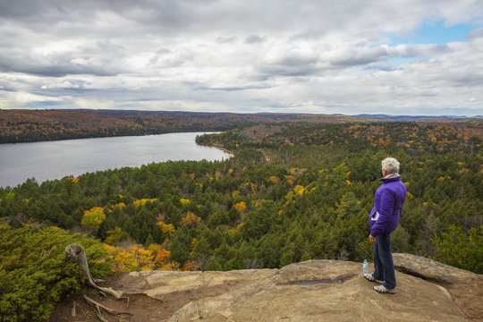 Woman looking out over Rock Lake from atop Booth's Rock, Algonquin Park; Ontario, Canada