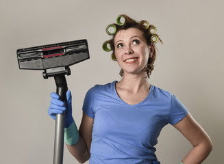 housewife with hair rollers and gloves happy smiling cheerful holding vacuum cleaner