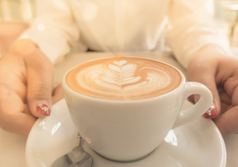 Closeup of woman holding warm latte hot cup of coffee