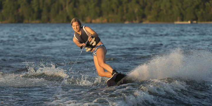 A young woman wakeboarding on a lake; Ontario, Canada