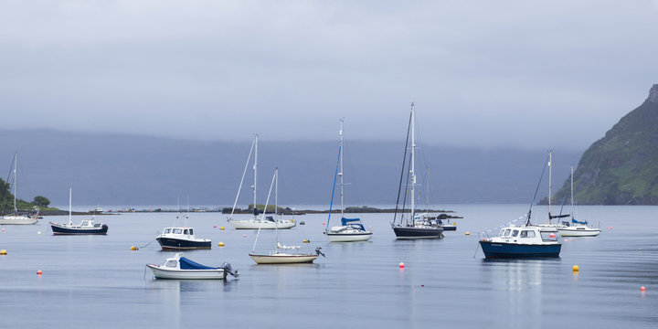 Boats moored in a tranquil Portree harbour; Skye Island, Scotland