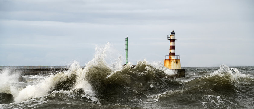 Lighthouse and splashing waves; Amble, Northumberland, England