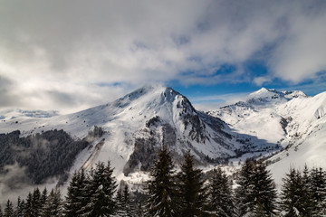 Mountains covered with snow and clouds and trees