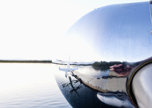 Reflection in nose cone of floatplane; Alaska, United States of America