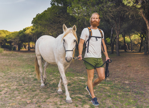 A man walking with a white horse; Cadiz, Andalusia, Spain