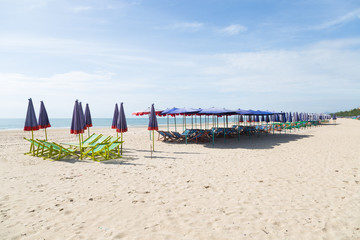 Beds and umbrellas on the beach.