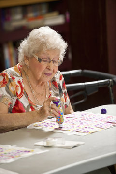 A senior woman playing bingo; Devon, Alberta, Canada