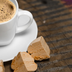 Coffee with foam and brown marshmallow on a wooden table