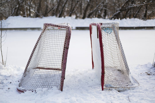 Two hockey nets in the snow beside a frozen outdoor rink; Wetaskiwin, Alberta, Canada