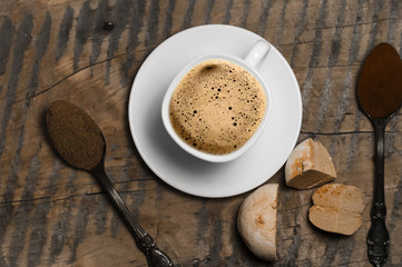 Coffee with foam and brown marshmallow on a wooden table