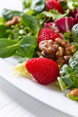 Green vegan salad with raspberry and nuts