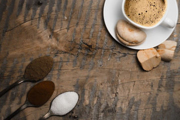 Coffee with foam and brown marshmallow on a wooden table