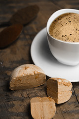 Coffee with foam and brown marshmallow on a wooden table