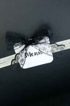 scritta menu su cartoncino con fiocco nero su sfondo scuro