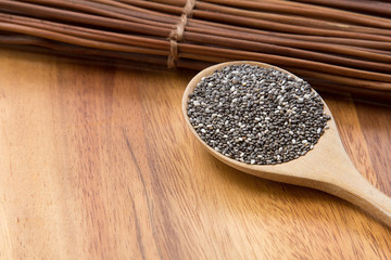 chia seeds (Salvia Hispanica) in a wooden spoon on wooden background