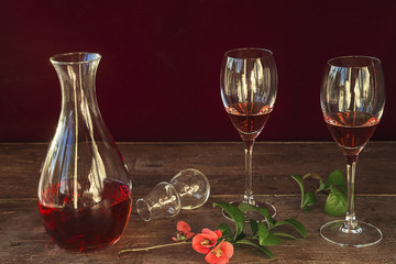 decanter and two glasses with pink wine on rustic wooden background