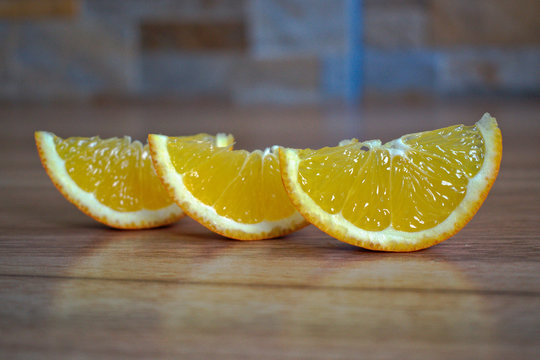 Closeup of orange wedges on a wooden table