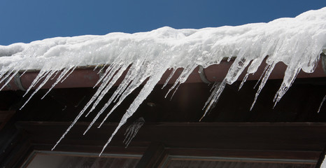 Icicles hanging from a gutter of a roof somewhere in the Bavarian Alps