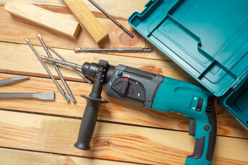 Electric hammer drill lies on a wooden table