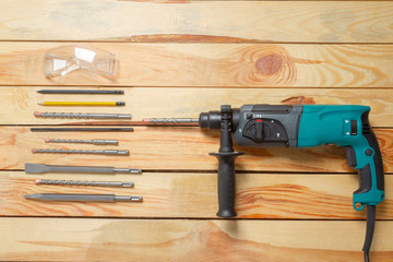Electric hammer drill lies on a wooden table