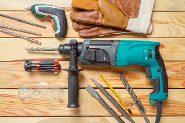 Electric hammer drill lies on a wooden table
