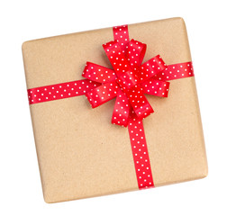 Gift box wrapped in brown recycled paper with red polka dot ribbon bow top view isolated on white background, clipping path included