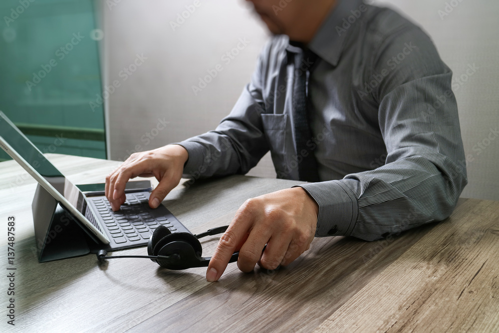 Poster Man using VOIP headset with digital tablet computer docking smart keyboard, concept communication, it support, call center and customer service help desk,filter film effect