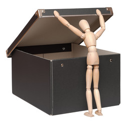 Who seeks will always find. Wooden lay figure looks in cardboard box. Isolated on white background.