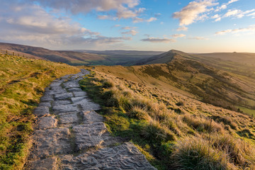 Rural stone footpath trail on ridge of hills in the British Peak District National Park on a Winter morning.