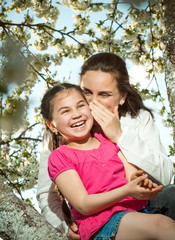 Fototapeta premium Cute little girl playing on tree in early spring