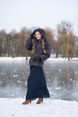 woman in a blue winter coat standing on the street in full growth